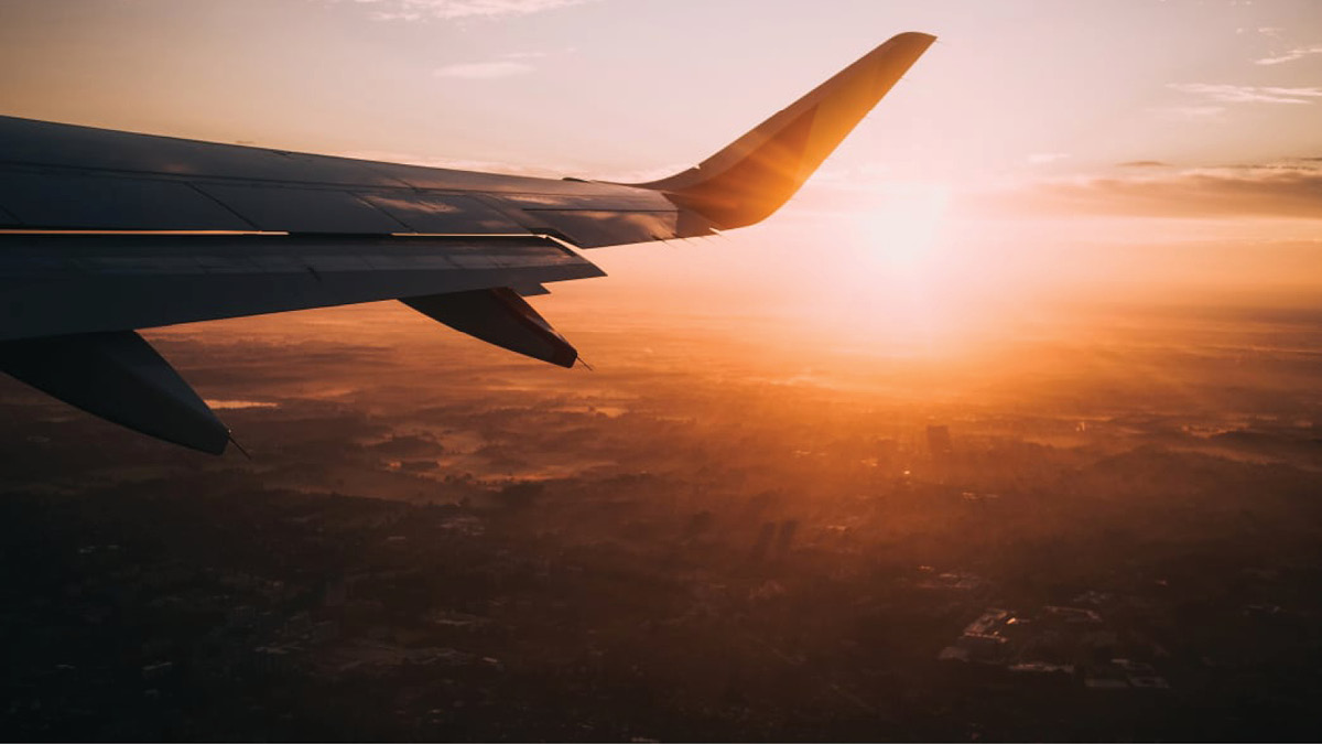 Airplane flying at sunrise